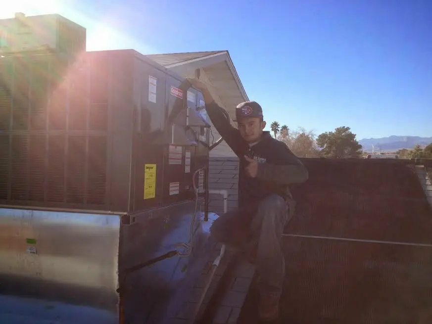 HVAC technician performing Heat Pump Repair on a rooftop unit in Greenville